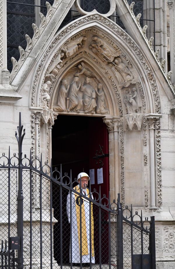 Настоятель cобора Парижской Богоматери Патрик Шове у входа в собор перед началом первой мессы после пожара - Sputnik Абхазия