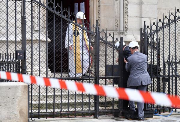 Настоятель cобора Парижской Богоматери Патрик Шове встречает у входа в собор людей, прибывших на мессу - Sputnik Абхазия
