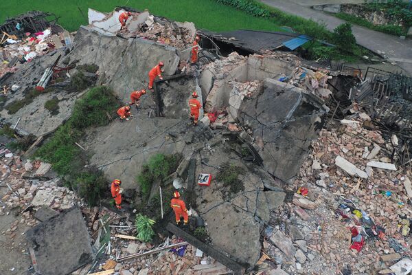 Спасатели на руинах здания после сильного землетрясения в городе Yibin китайской провинции Сычуань - Sputnik Абхазия