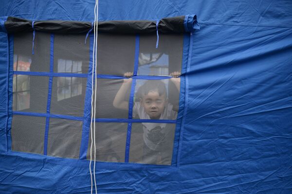 Ребенок во временном лагере для жертв землетрясения в городе Yibin, китайской провинции Сычуань  - Sputnik Абхазия