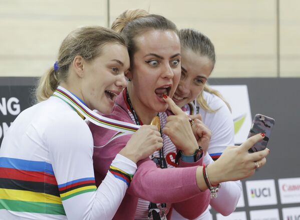 Российские спортсменки Анастасия Войнова и Дарья Шмелева позируют для селфи с неизвестной девушкой, завоевав золотую медаль в командном спринте среди женщин на чемпионате мира по велоспорту в Гонконге - Sputnik Абхазия