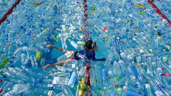 Ребенок плавает в бассейне, наполненном пластиковыми бутылками, во время информационной кампании, посвященной Всемирному дню океанов в Бангкоке, Таиланд - Sputnik Абхазия