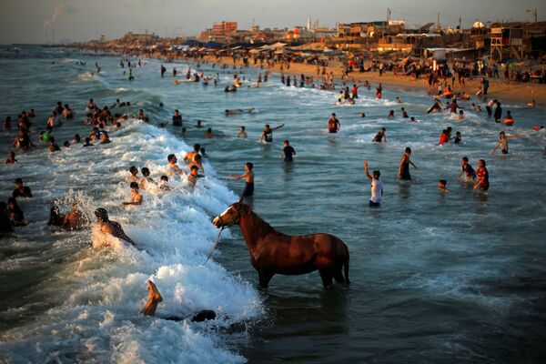 Люди купаются в водах Средиземного моря в жаркий день в северной части сектора Газа - Sputnik Абхазия
