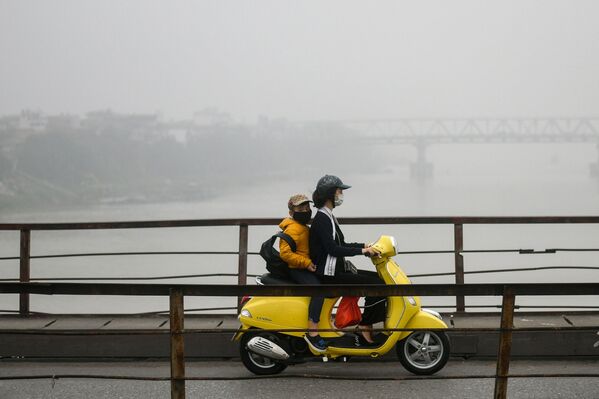 Женщина с ребенком в масках для лица едут по мосту среди смога над Ханоем - Sputnik Абхазия