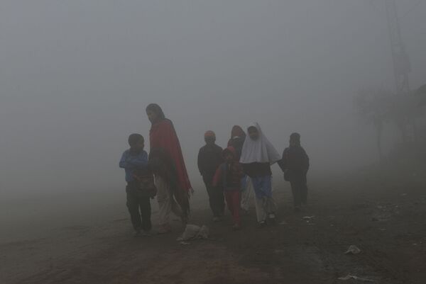 Матери ведут детей в школу вдоль дороги в условиях сильного тумана и смога в Лахоре - Sputnik Абхазия