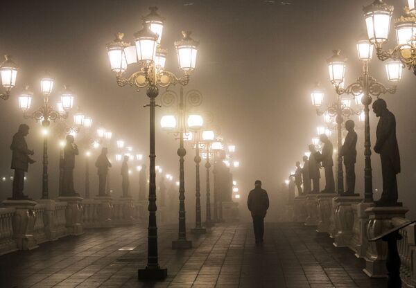 Мужчина идет по мосту через густой туман и смог в Скопье вечером 22 декабря 2018 года - Sputnik Абхазия