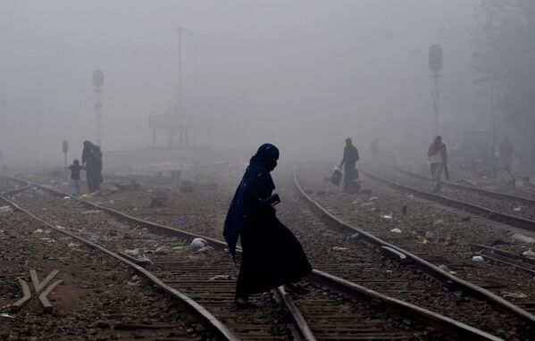 Пакистанская женщина идет по густому туману через железнодорожные пути - Sputnik Абхазия