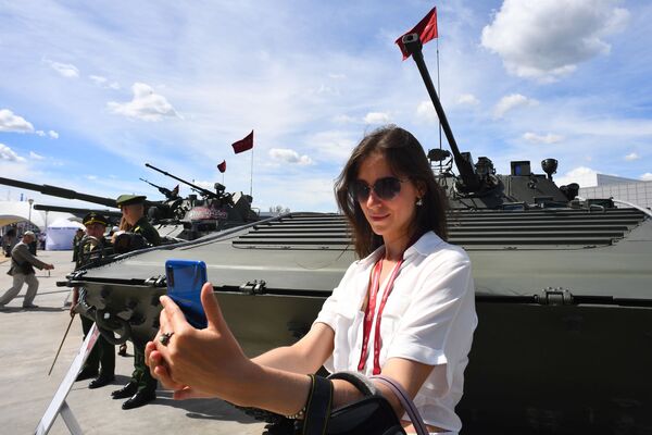 Посетительница фотографируется у боевой машины пехоты БМП-2 на Международном военно-техническом форуме Армия-2019 - Sputnik Абхазия