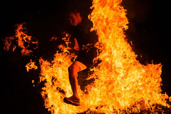 Мужчина прыгает через костер на праздновании Ночи святого Хуана в Испании - Sputnik Абхазия