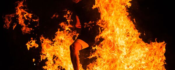 Мужчина прыгает через костер на праздновании Ночи святого Хуана в Испании Мужчина прыгает через костер на праздновании Ночи святого Хуана в Испании - Sputnik Аҧсны