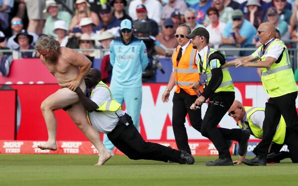 Сотрудники службы безопасности пытаются задержать голого мужчину, выбежавшего на поле во время матча по крикету между командами Англии и Новой Зеландии - Sputnik Абхазия