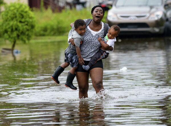 Мать несет на руках своих детей во время наводнения в Новом Орлеане  - Sputnik Абхазия