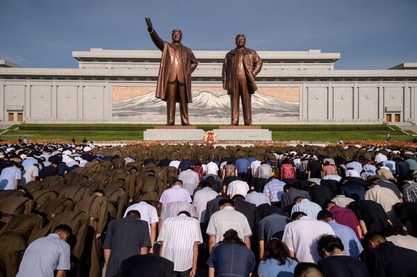Жители Пхеньяна во время минуты молчания у памятника Ким Ир Сену и Ким Чен Иру в день отмечания 25-летия со дня смерти Ким ИМ Сена - Sputnik Абхазия