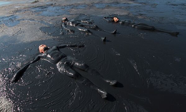 Отдыхающие принимают грязевые ванны в Чокракском озере недалеко от села Курортное в Крыму - Sputnik Абхазия