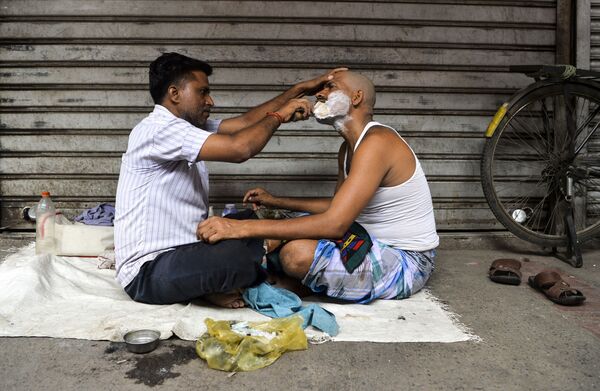 Парикмахер бреет клиента в старом квартале Нью-Дели, Индия - Sputnik Абхазия