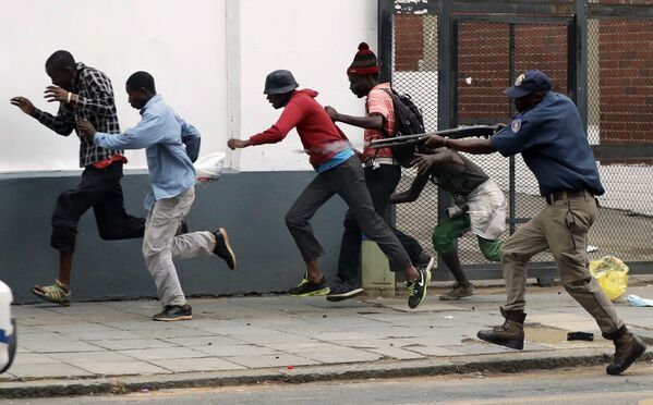 Полицейский разгоняет демонстрантов на антимигрантском митинге в Претории, ЮАР. - Sputnik Абхазия