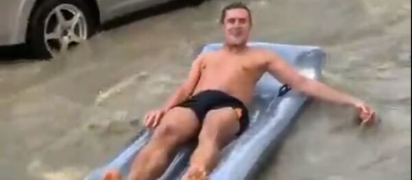 Парень на надувном матрасе во время наводнения в Сочи - Sputnik Абхазия