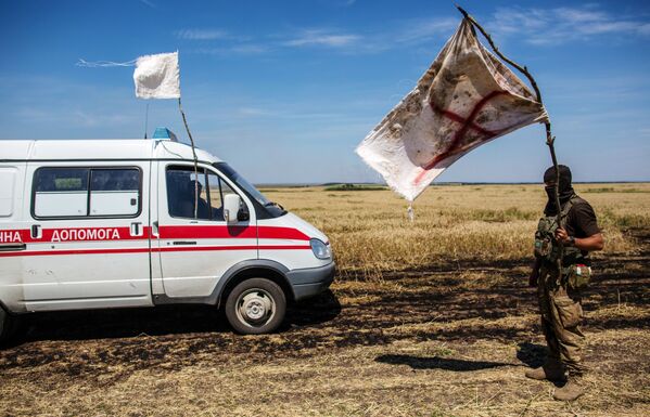 Украинский военный с белым флагом во время передачи убитых на нейтральной территории вблизи поселка Диброво в Донецкой области - Sputnik Абхазия