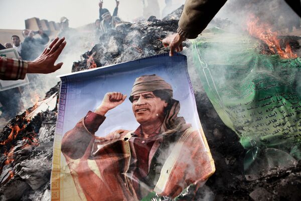 Жители Бенгази сжигают портреты Муамара Каддафи, плакаты с его цитатами и Зеленую книгу Каддафи - Sputnik Абхазия