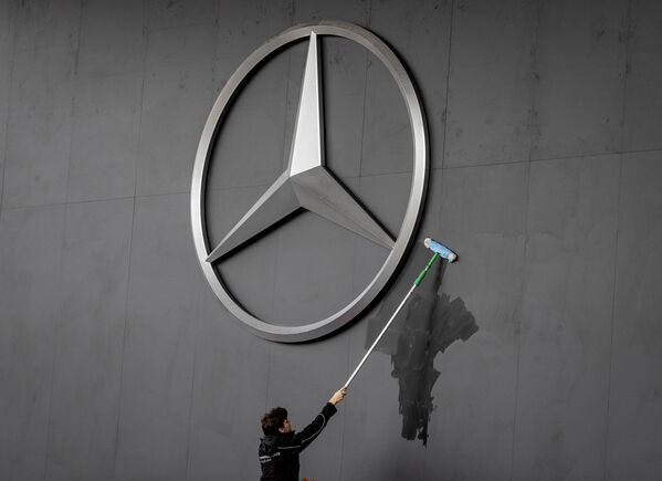 Работник протирает логотип Mercedes на автосалоне IAA во Франкфурте, Германия - Sputnik Абхазия