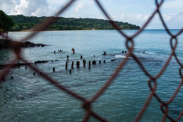 Вид сквозь решетку на купающихся людей в Никарагуа - Sputnik Абхазия