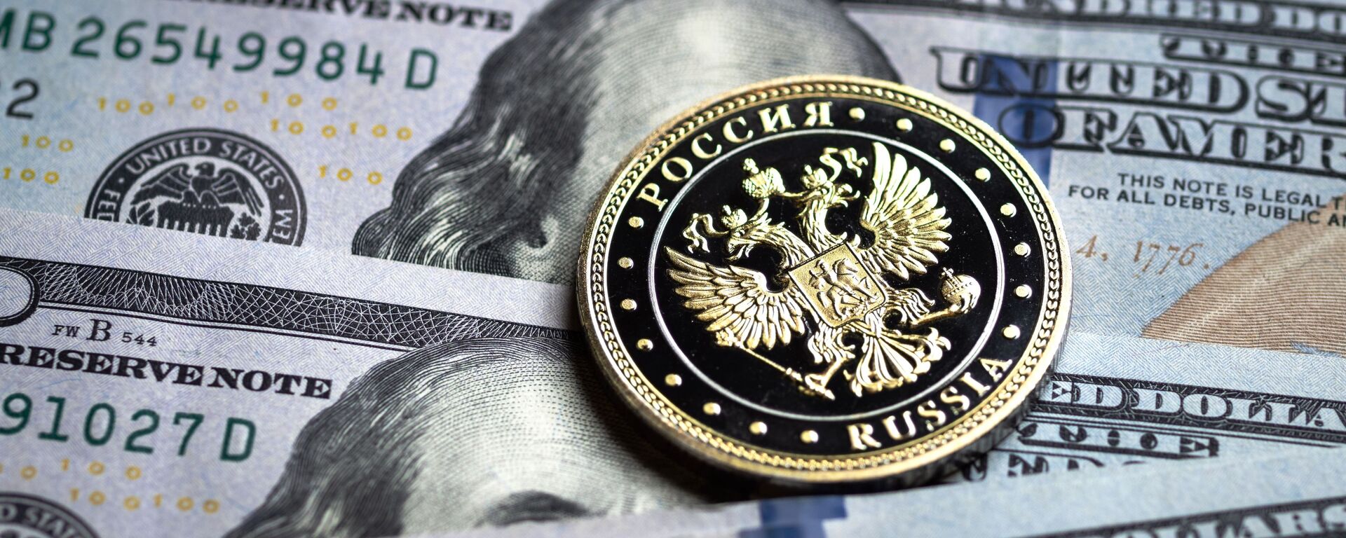 Купюры американских долларов и монета с гербом Российской Федерации. - Sputnik Абхазия, 1920, 29.05.2022