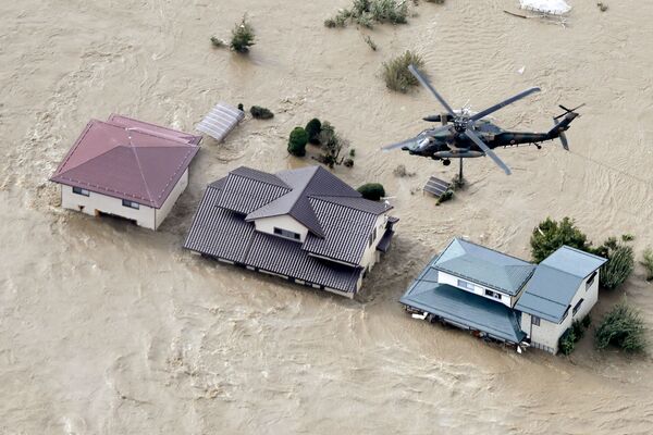 Вертолет над жилыми районами, затопленными рекой Чикума после тайфуна Хагибис в Нагано, центральная Япония - Sputnik Абхазия