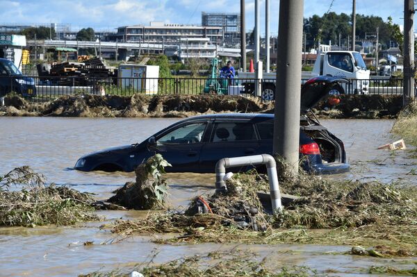 Автомобиль стоит на территории, затопленной в результате тайфуна Хагибис в Хигаси-мацуяме, префектура Сайтама, Япония - Sputnik Абхазия