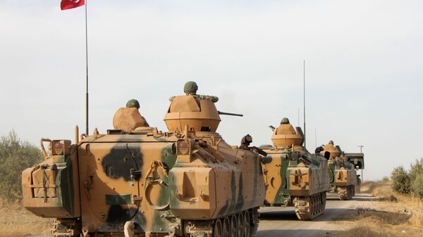 Турецкие солдаты перевозятся на бронетранспортерах через город Тухар, к северу от северного сирийского города Манбидж, 14 октября 2019 года, когда Турция и ее союзники продолжают наступление на удерживаемые курдами пограничные города на северо-востоке Сирии. - Sputnik Абхазия
