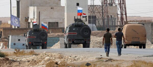 Флаги России и Сирии на военных автомобилях в сирийском городе Манбидж Флаги России и Сирии на военных автомобилях в сирийском городе Манбидж - Sputnik Абхазия