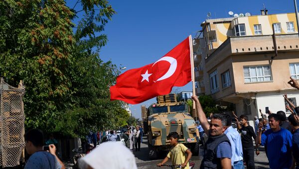 Мужчина развевает турецкий флаг, когда турецкие войска едут на автомашинах в направлении Тал-Абьяда в Сирии - Sputnik Абхазия