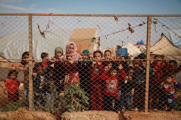 Сирийские дети у забора палаточного лагеря недалеко от деревни Кафр-Лусин, Сирия - Sputnik Абхазия