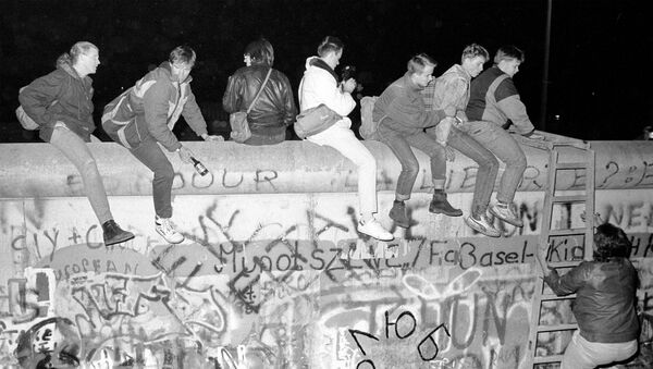 На фото сверху граждане Западной Германии сидят на вершине Берлинской стены на Zimmer Strasse 9 ноября 1989 года, и внизу -  то же место 30 октября 2019 года, Германия - Sputnik Абхазия