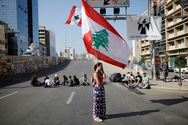 Женщина с флагом Ливана во время антиправительственных протестов в Бейруте - Sputnik Абхазия