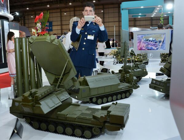 Посетитель выставки осматривает макеты военной техники, представленные на стенде АО Рособоронэкспорт на международном авиасалоне Dubai Airshow 2019 в Дубае - Sputnik Абхазия