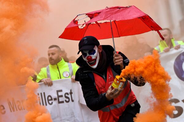Мужчина в маске клоуна с дымовой шашкой во время протеста против пенсионной реформы в Марселе, Франция - Sputnik Абхазия