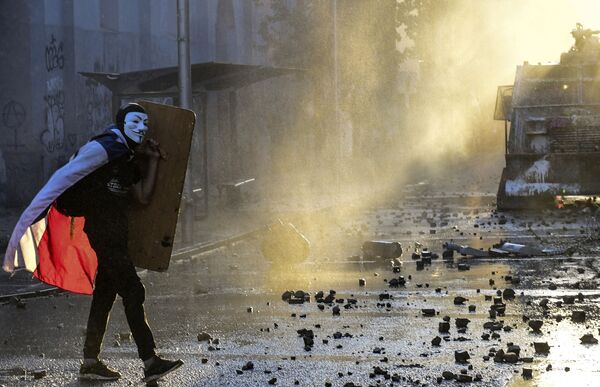Демонстрант в маске Гая Фокса на акции протеста против правительства в Сантьяго  - Sputnik Абхазия