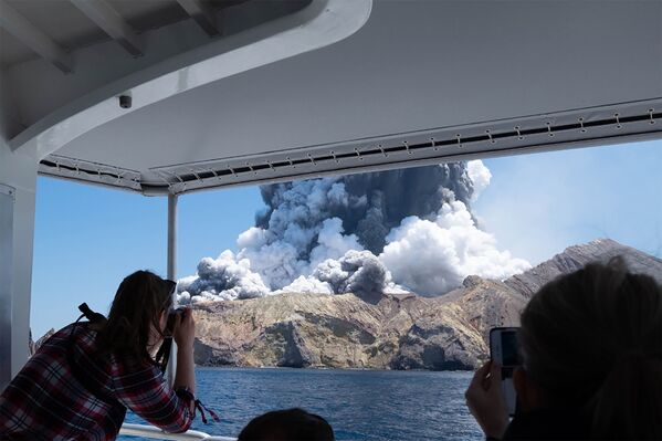 Туристы снимают извержение вулкана на острове Уайт-Айленд в Новой Зеландии - Sputnik Абхазия