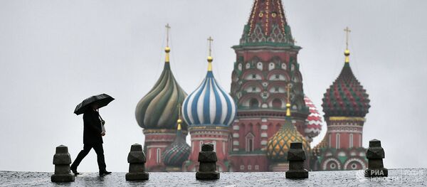 Прохожий во время дождя на Красной площади в Москве - Sputnik Абхазия