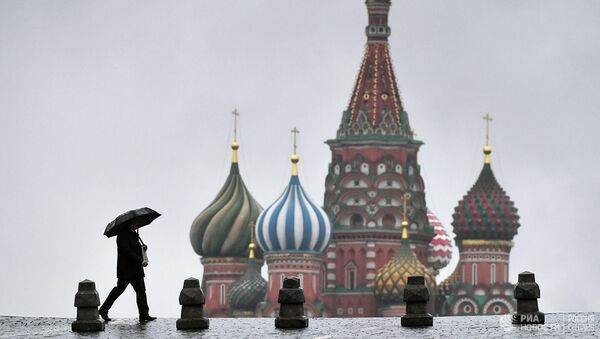 Прохожий во время дождя на Красной площади в Москве - Sputnik Абхазия