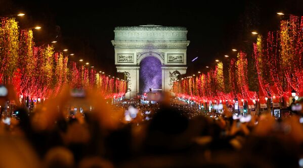 Зрители во время праздничного светового шоу перед Триумфальной аркой в Париже - Sputnik Абхазия