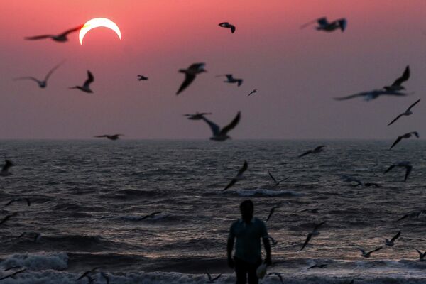 Мужчина на пляже в Кувейте во время частичного солнечного затмения - Sputnik Абхазия