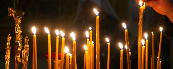 Женщина зажигает свечу  Женщина зажигает свечу  - Sputnik Абхазия