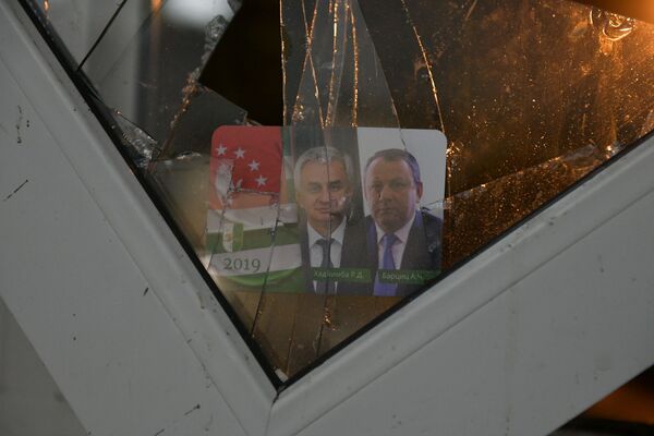 Календарь с портретом бывших президента и вице-президента, в одном из выбитых при штурме окон администрации  - Sputnik Абхазия