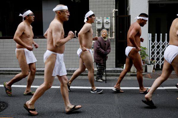 Мужчины в набедренных повязках бегут вокруг храма в Токио, готовясь к традиционному купанию в холодной воде. - Sputnik Абхазия