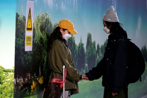 Пара в медицинских масках в аэропорту Пудун в Шанхае - Sputnik Абхазия