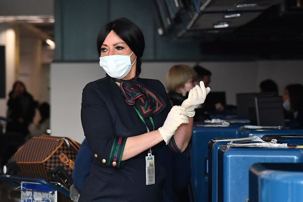 Сотрудница аэропорта в маске и перчатках до проверки пассажиров в Риме  - Sputnik Абхазия