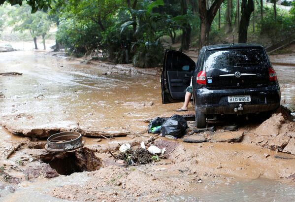 Поврежденный автомобиль и улица после сильного наводнения, вызванного дождями в Белу-Оризонти, Бразилия - Sputnik Абхазия