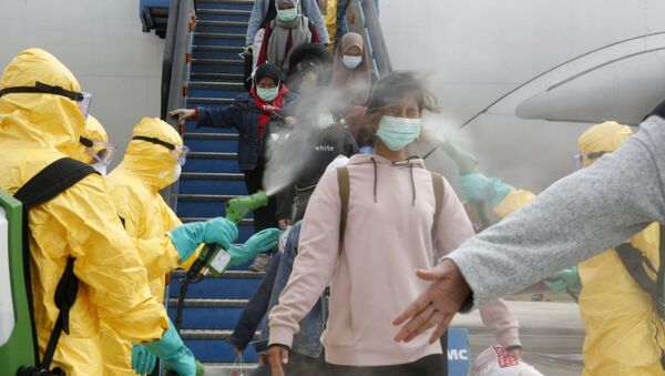 Медики опрыскивают индонезийских граждан антисептиком после прибытия из китайского Уханя, центра эпидемии коронавируса - Sputnik Абхазия