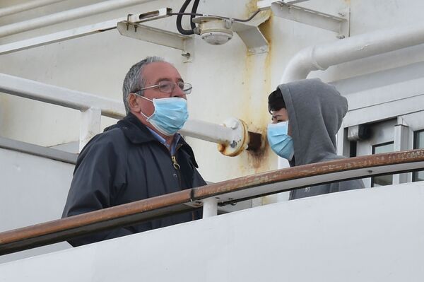 Пассажиры в медицинских масках на борту круизного лайнера Diamond Princes, помещенного в карантин у японского порта Йокогама - Sputnik Абхазия